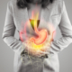 An image of a woman with a graphical image of an inflamed stomach and esophagus on the front of her symbolizing acid reflux.