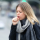 An image of a woman coughing into her fist,