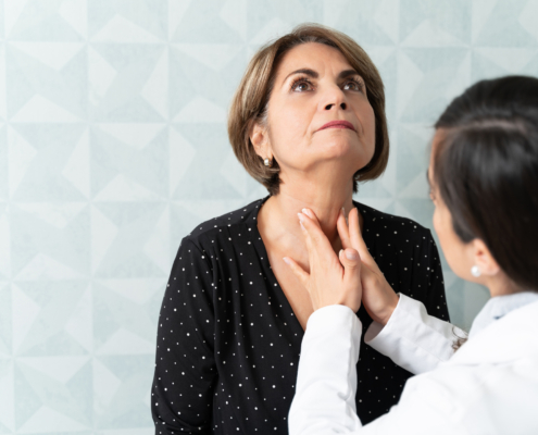 An image of a doctor feeling a patient's throat for dyphagia.