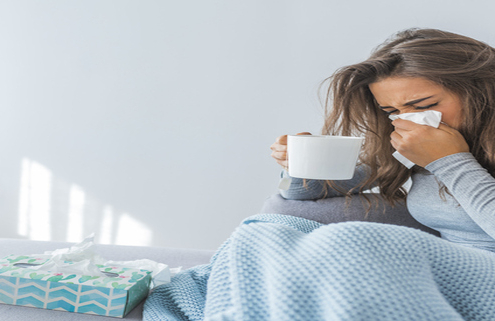 An image of a woman blowing her nose to relieve stuffy nose.