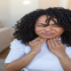 Post Nasal Drip: Symptoms, Causes, Treatment Options & More An image of a woman with sore throat pain.